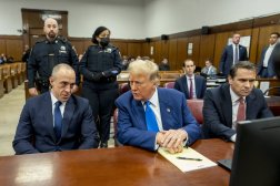 الرئيس السابق دونالد ترمب يتحدث مع وكيل الدفاع عنه المحامي إميل بوف قبل بدء جلسة الجمعة في محكمة نيويورك (أ.ب)