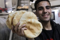 فلسطيني يمسك بالخبز الأبيض لأول مرة بعد أشهر من إغلاق المخابز وسط الحرب (رويترز)