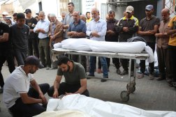 فلسطينيون بجوار جثث الذين قُتلوا خلال الغارات الإسرائيلية في رفح (رويترز)